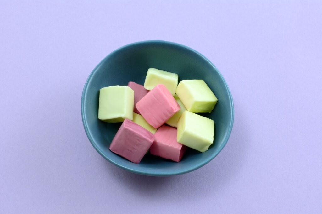 purple background with blue bowl with green and pink calcium citrate chews