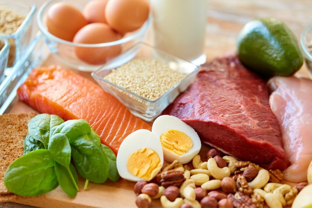 protein sources including raw salmon, hard boiled eggs, raw steak, chicken, and nuts 