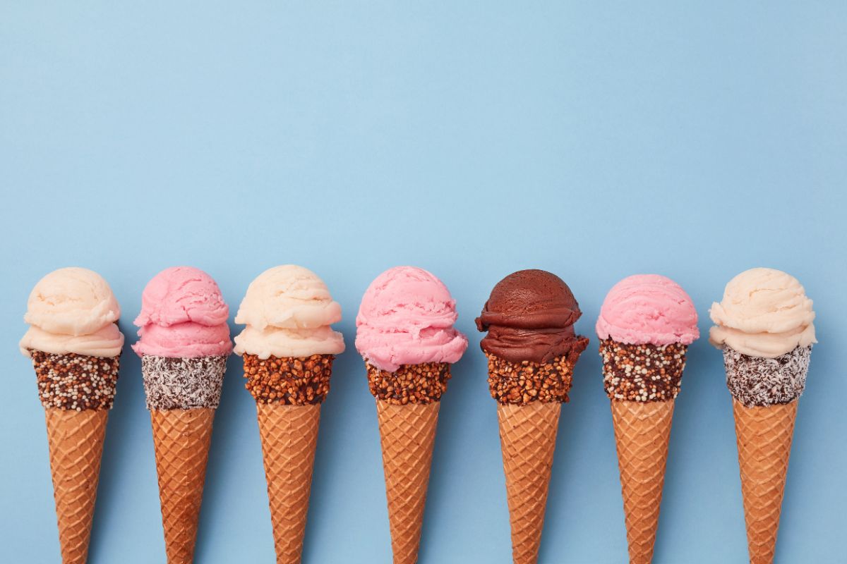 Multiple ice cream cones in a line with a blue background