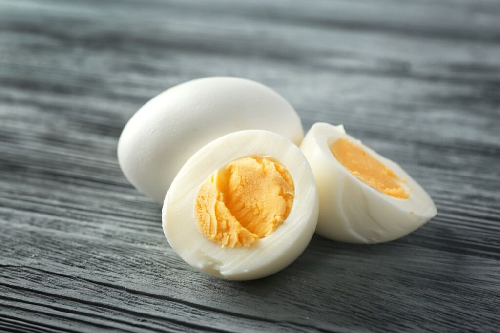 gray colored wooden background with 3 halved hard boiled eggs